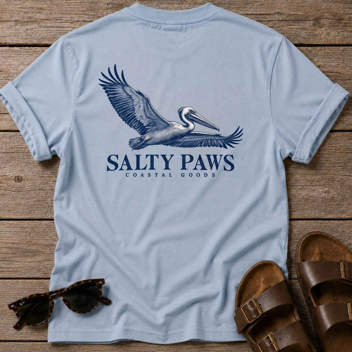 Gliding Pelican Coastal Goods Back Design T-Shirt in Light Blue, Salty Paws T-Shirt, back design flat lay