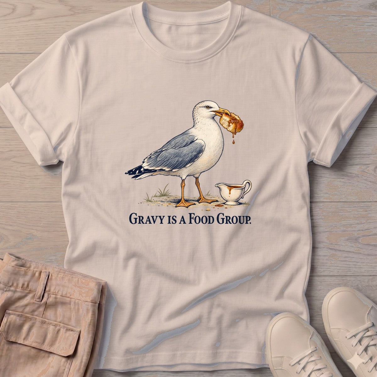 Gravy Is a Food Group Seagull T-Shirt in Sand, Salty Paws T-Shirt, front design flat lay