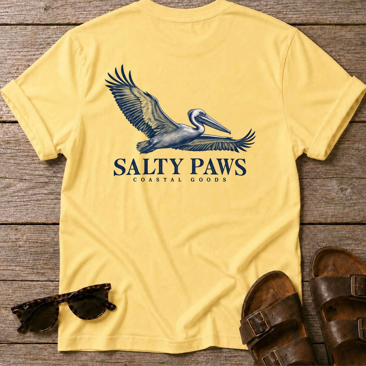 Gliding Pelican Coastal Goods Back Design T-Shirt in Daisy, Salty Paws T-Shirt, back design flat lay