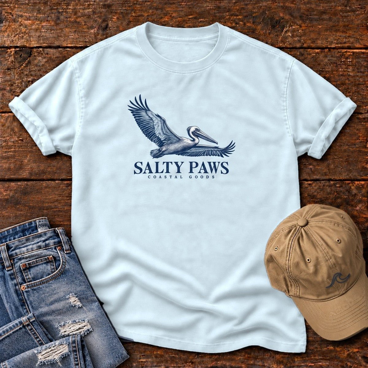 Gliding Pelican Coastal Goods T-Shirt in Chambray, Salty Paws Comfort Colors T-Shirt, front design flat lay