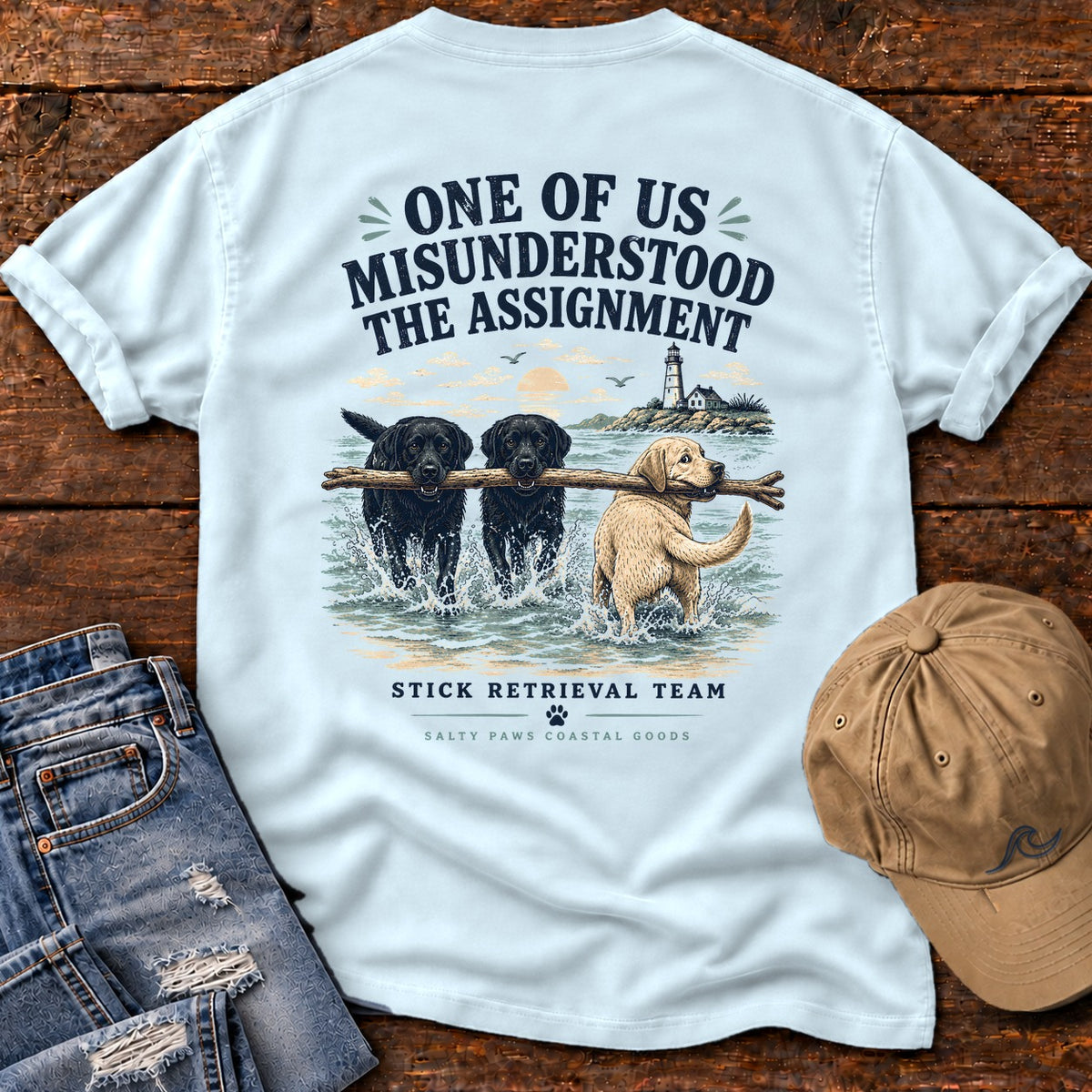 One of Us Misunderstood the Assignment Comfort Colors T-Shirt in Chambray, back design flat lay